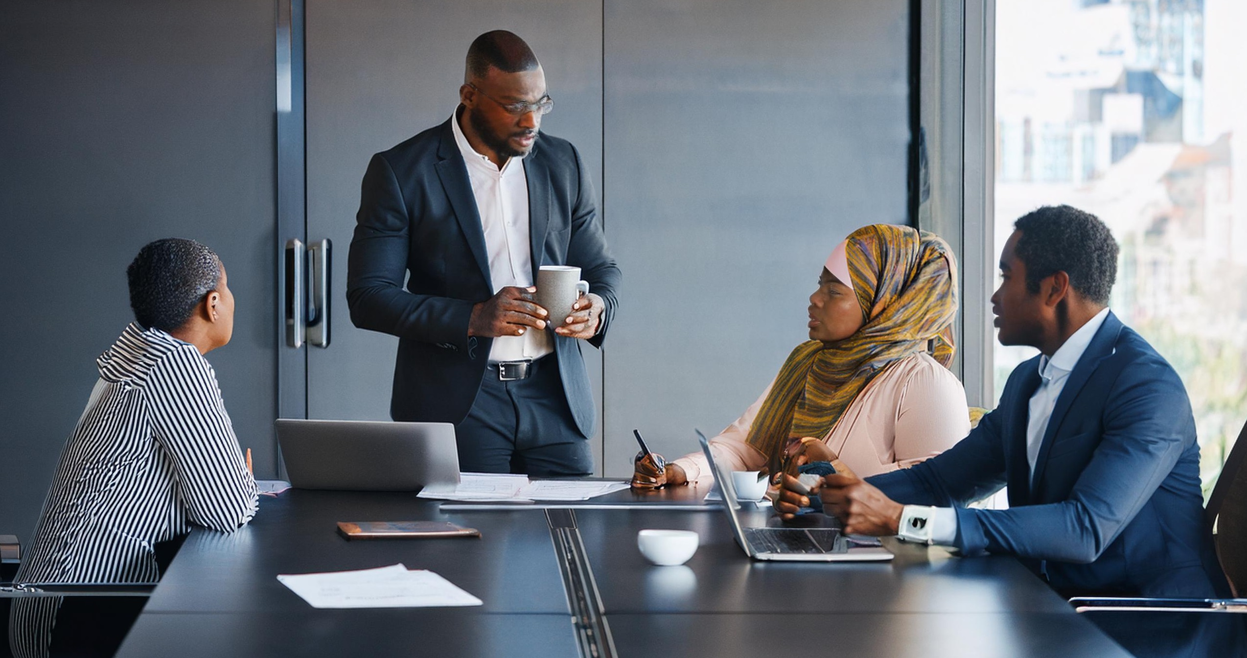 Governing -The image shows a business meeting taking place in a modern African conference room. Five Af